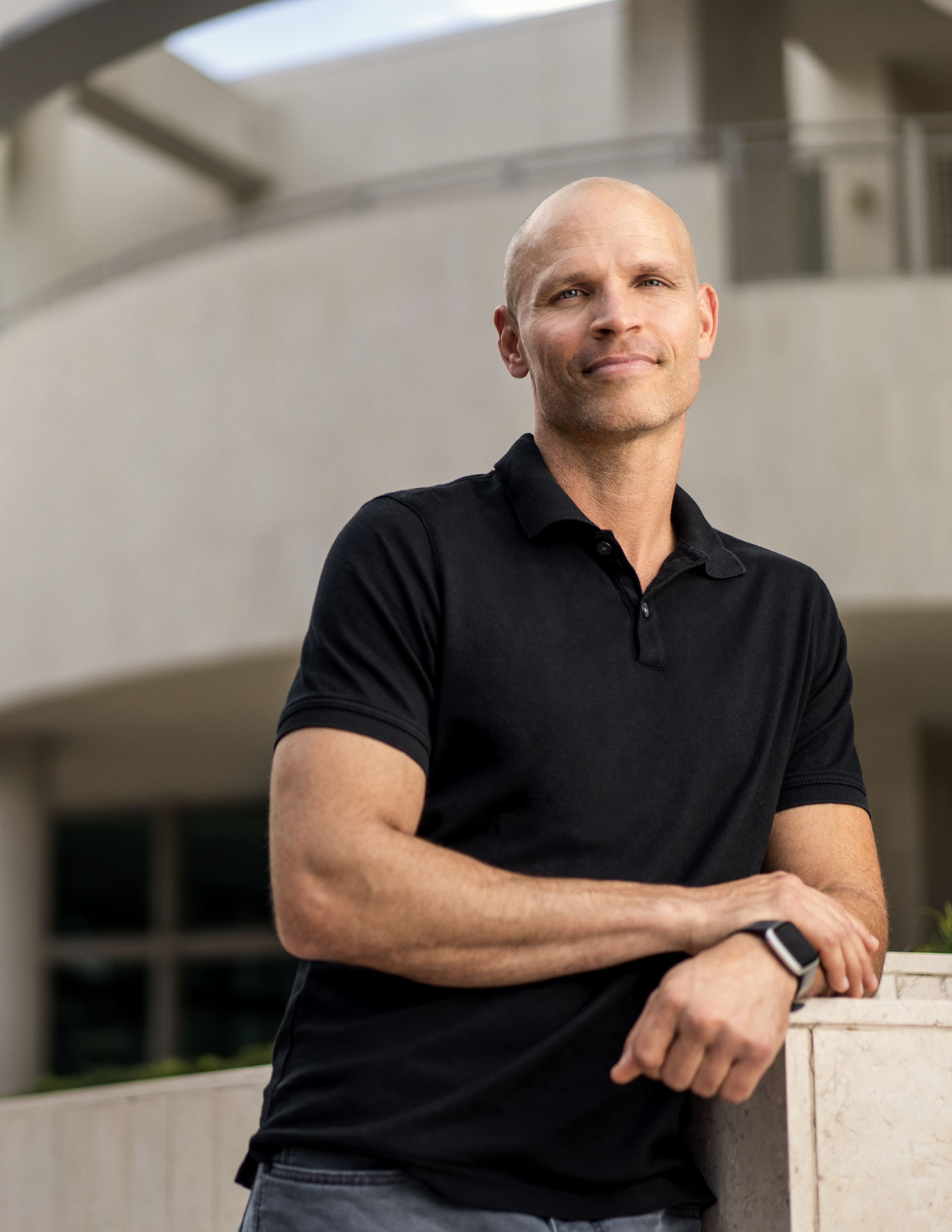 Man with a black shirt poses for a photo on campus