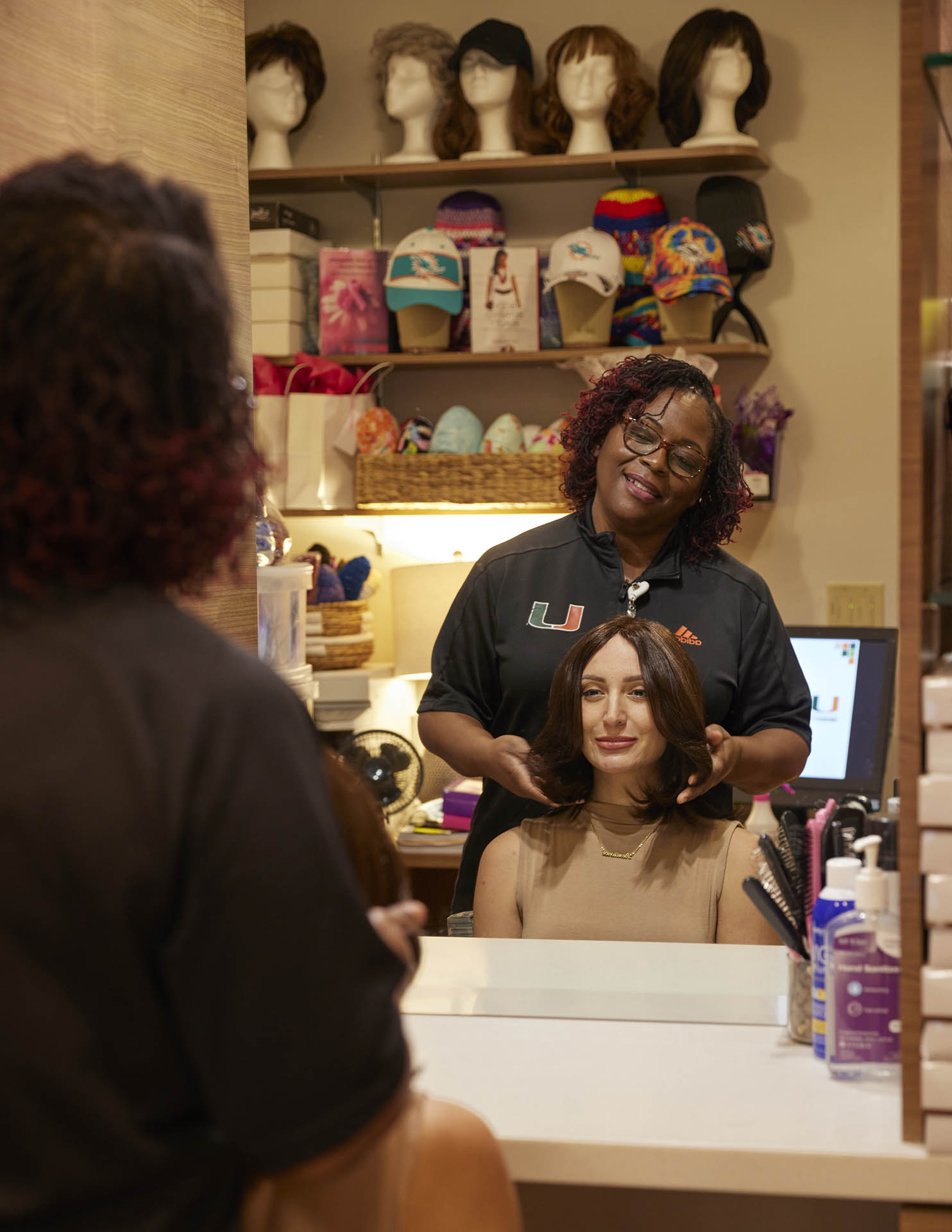 Concierge Coordinator Tangela Hillery adjusts a wig for Madeline Mordarski