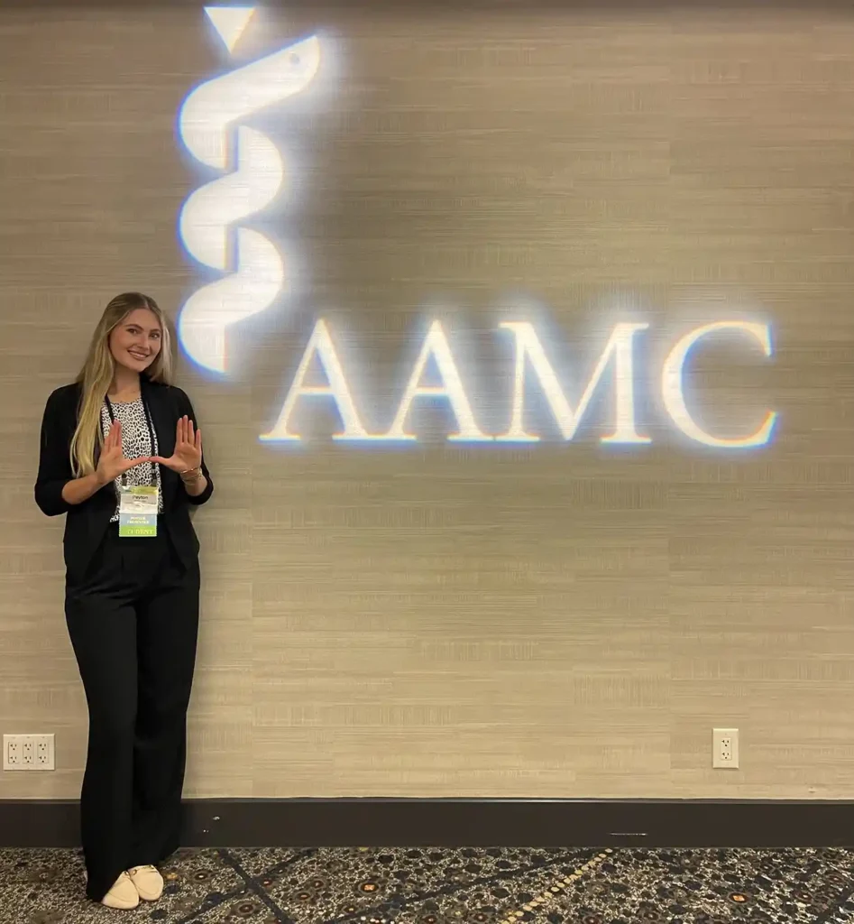 student poses for photo at AAMC event